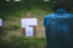 Man firing a handgun at target in shooting range
